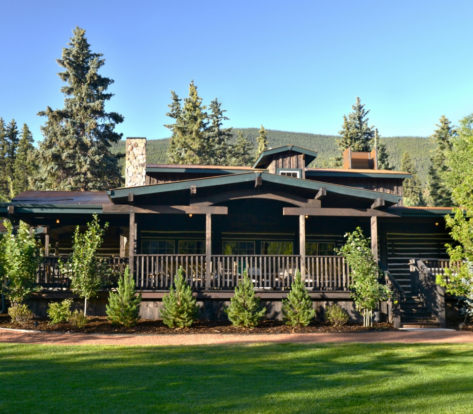 A house made of wood surrounded by trees.