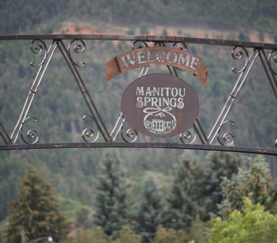 A gate sign that says Welcome to Manitou Springs