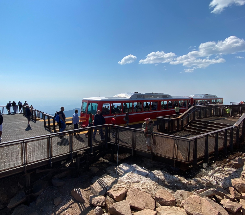 Platform with passengers departing train on top of mountain