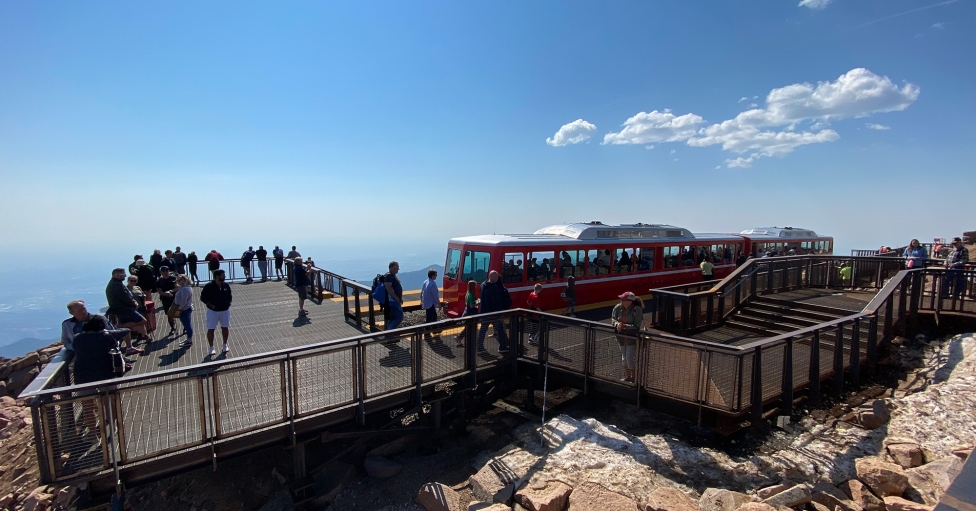 Platform with passengers departing train on top of mountain