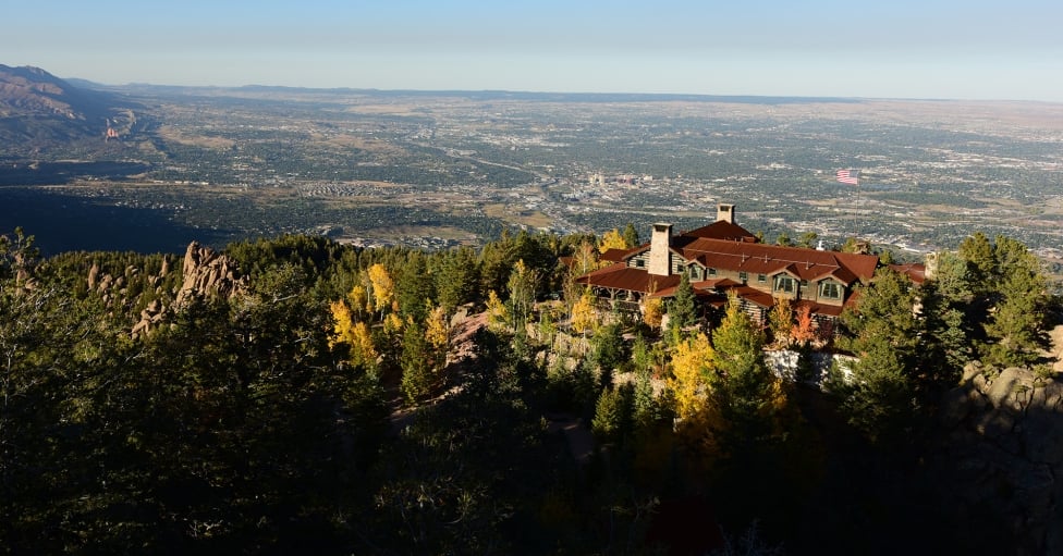 Building on mountain at sunset with blue skies and American flag flying
