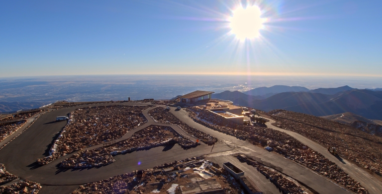 sunrise on top of mountain with building