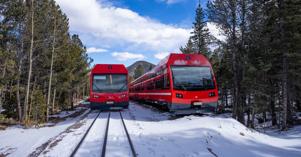 A Couple Of Red Trains On Tracks In The Snow