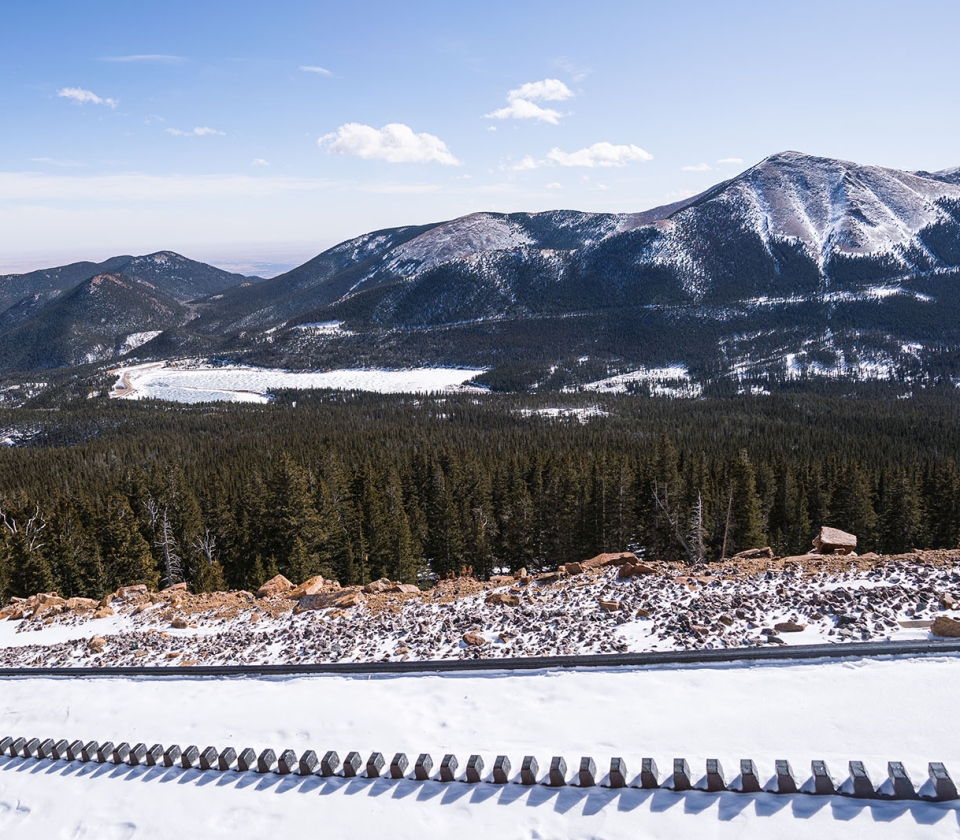 A Snowy Landscape With Trees And Mountains